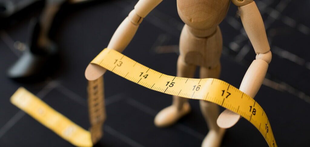 Measuring tape and little wooden man